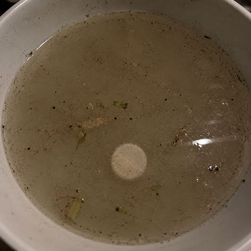 Pearl tablet in dirty water with visible wax and residue